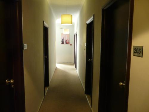 a hallway with a long corridor with two doors and a light at San Nectarios in Parga