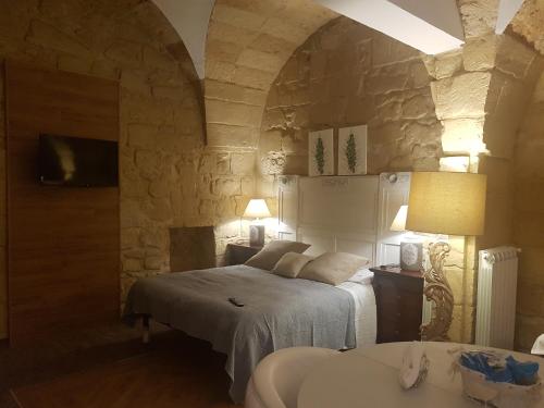 a bedroom with a bed and a stone wall at Fjore Di Lecce in Lecce