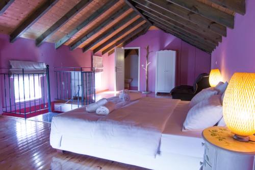 uma cama grande num quarto com paredes roxas em Kefalonia Ammos Villa em Lixouri