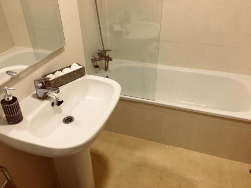 een badkamer met een wastafel en een bad bij La Isla in Murcia