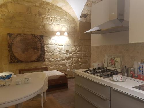 a kitchen with a stove and a sink and a table at Fjore Di Lecce in Lecce