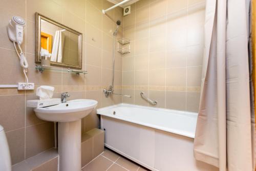 a bathroom with a sink and a toilet and a bath tub at Hotel Menshikov in Ulan-Ude