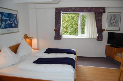 ヘンネフにあるHotel Johnelのベッドルーム1室(ベッド2台、窓付)