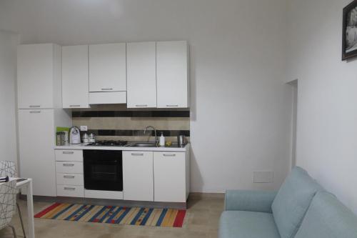 ノートにあるCasa Giacchinoの白いキャビネットと青いソファ付きのキッチンが備わります。