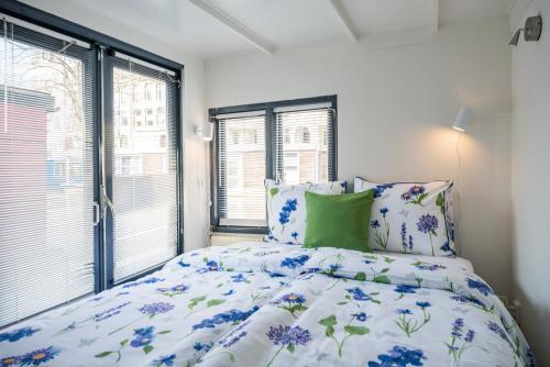a bedroom with a bed with blue flowers at Houseboat Lady Jane in Amsterdam