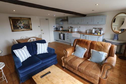 Monmouth House Apartments, Lyme Regis Old Town, dog friendly, parking في ليم ريجيس: غرفة معيشة مع كرسيين وأريكة زرقاء