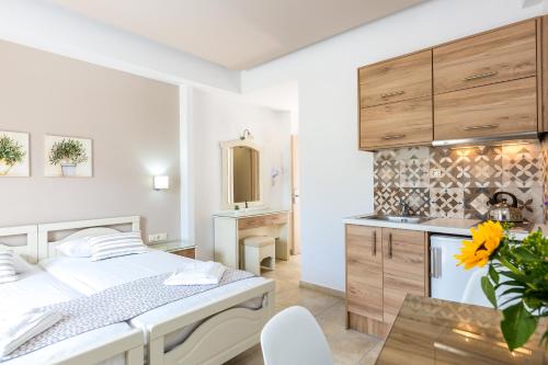 a white bedroom with a bed and a kitchen at Amalia Apartments in Balíon