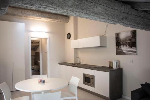 a kitchen and dining room with a white table and chairs at Residenza La Torre in Mantova