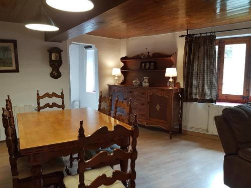 a dining room with a wooden table and chairs at Apartaments Can Bundanci in Setcases