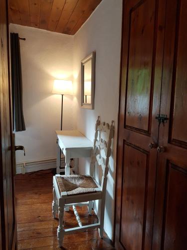 a room with a table and a chair and a lamp at Apartaments Can Bundanci in Setcases