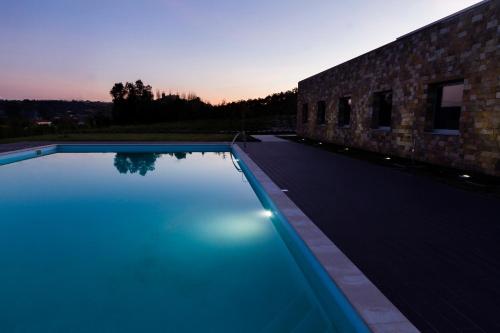 a swimming pool in front of a brick building at Hotel Vila D'Óbidos in Óbidos