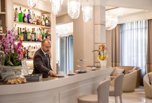 a man sitting at a bar in a restaurant at Hotel Dei Fiori Restaurant - Meeting & Spa in Alassio