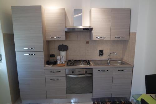 una cocina con armarios de madera y fregadero en Appartamento a 100 metri da Piazza della Repubblica Aria condizionata CIR 0053, en Aosta