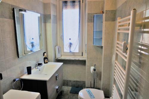 baño con lavabo, aseo y ventanas en Appartamento a 100 metri da Piazza della Repubblica Aria condizionata CIR 0053, en Aosta
