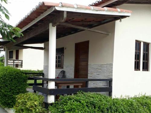 a house with a wooden bench under a pergola at Pousada Vale Encantado in Serra de São Bento