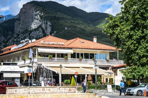 un bâtiment avec une montagne en arrière-plan dans l'établissement Olympus View Rooms Sauna & Spa, à Litochoro