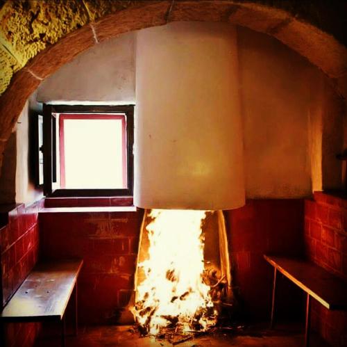 a room with a fireplace and a window and a bench at Trulli Panoramici in Alberobello