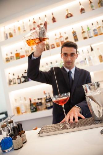a man in a suit holding a glass of wine at Miramare The Palace Resort in Sanremo