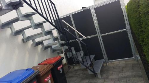 a set of stairs next to a building with trash cans at FeWo - bei Tati 95qm in Singen
