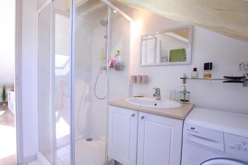 a white bathroom with a shower and a sink at Appartement Barcelonnette in Barcelonnette