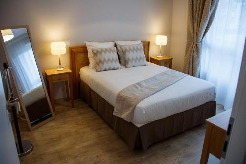 ティオンヴィルにあるDomitys Le Pavillon de Dianeのベッドルーム1室(ランプ2つ、鏡付)