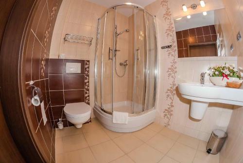 a bathroom with a sink, toilet and shower at Hotel Czardasz Spa & Wellness in Płock