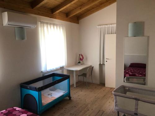 マルチェージネにあるVilla Piaのベビーベッド付きの部屋、デスク付きのベッドルーム1室が備わります。