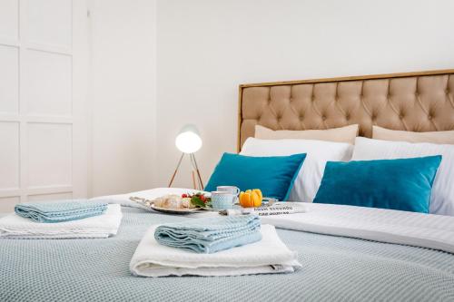 a bed with towels and a tray of food on it at Three square apartment in Kotor