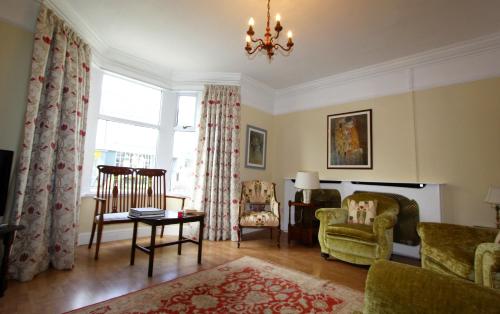 a living room with chairs and a chandelier at 81 Eastgate in Cowbridge