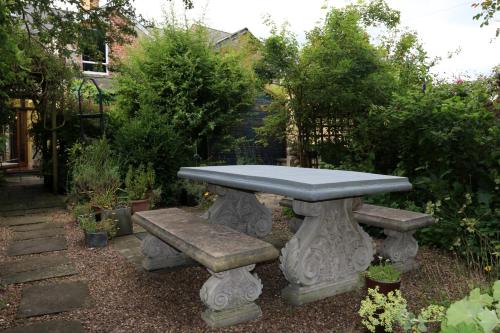 a stone picnic table and benches in a garden at 81 Eastgate in Cowbridge