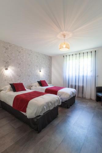 a hotel room with two beds and a chandelier at Chambres du Bout du Monde in Landévennec