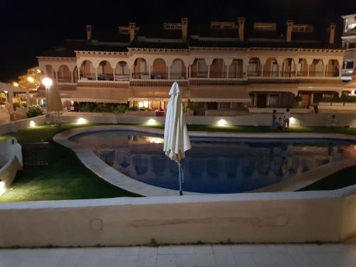 una piscina frente a un edificio por la noche en Retiro de Levante, en Santa Pola