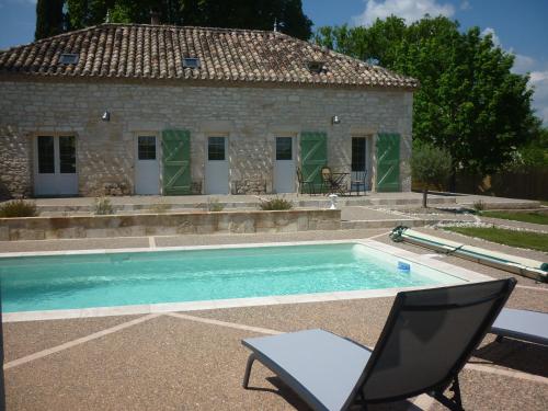 a swimming pool with a chair and a house at Pèque-Lèbre in Saint-Daunès