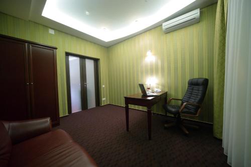a room with a desk and a chair and a lamp at Victoria Hotel in Kharkiv