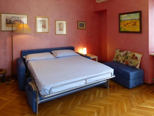 Casa Clemente in Cit Turin في تورينو: غرفة نوم بسرير واريكة زرقاء
