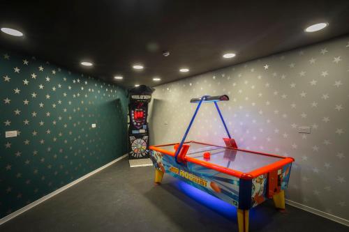 a room with a ping pong table next to a wall with stars at Leonardo Laura Beach & Splash Resort in Paphos City