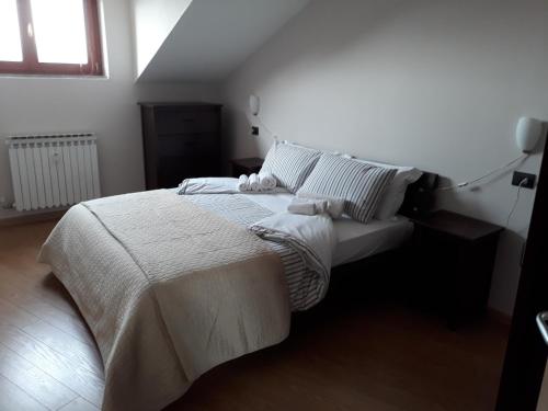 CarrùにあるYour House in Langaのベッドルーム1室(大型ベッド1台、白いシーツ、枕付)