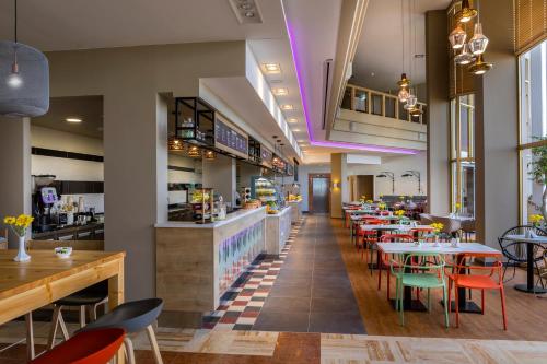 a restaurant with tables and chairs and a bar at Leonardo Laura Beach & Splash Resort in Paphos City
