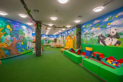 a childrens play area with a large mural on the walls at Leonardo Laura Beach & Splash Resort in Paphos City