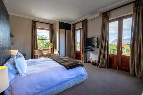 - une chambre avec un grand lit et une grande fenêtre dans l'établissement Nova Constantia Boutique Residence, au Cap