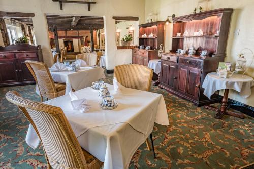 a restaurant with two tables and chairs with white table cloth at Marston Farm Hotel in Sutton Coldfield