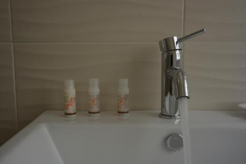a bathroom sink with a faucet and four bottles at Il Rifugio Dei Templari in Lecce