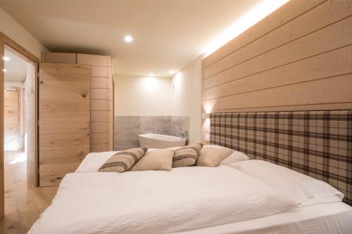a bedroom with a large white bed in a room at Hotel La Baita in Folgaria