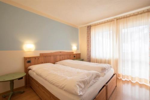 a bedroom with a large bed and a window at Hotel La Baita in Folgaria