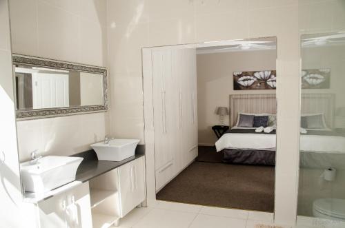 a bathroom with a sink and a mirror and a bed at Goulden Street Guest House in East London