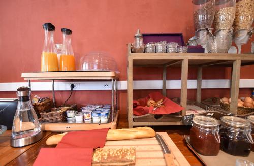 una mesa con pan y otros artículos. en Hôtel A casa di Maria Cicilia, en Ghisonaccia