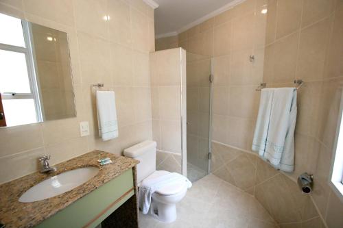a bathroom with a toilet and a sink and a shower at Cinelandia Hotel in Sao Paulo