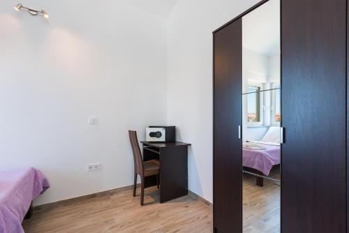 a bedroom with a mirror and a desk with a microwave at Guesthouse Bencun Medulin in Medulin