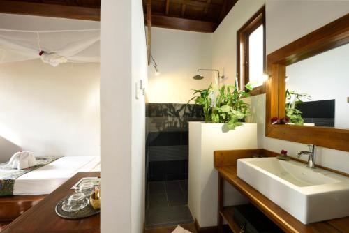 La Maison Birmane Boutique Hotel في نياونغ شوي: حمام مع مغسلة وسرير في الغرفة