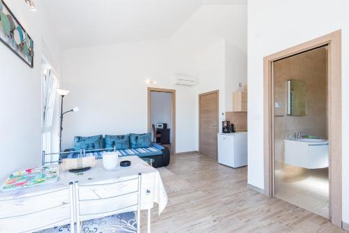 a white living room with a bed and a table at Guesthouse Bencun Medulin in Medulin